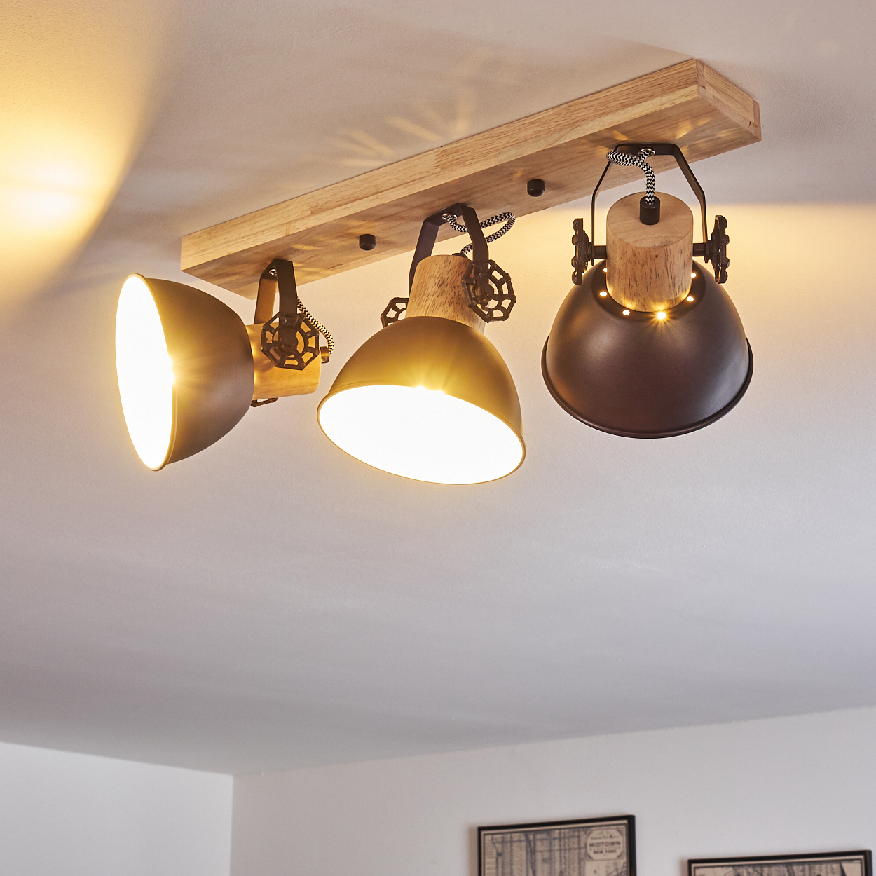 Deckenleuchte aus Holz mit drei Lampenschirmen in Braun und Messing.