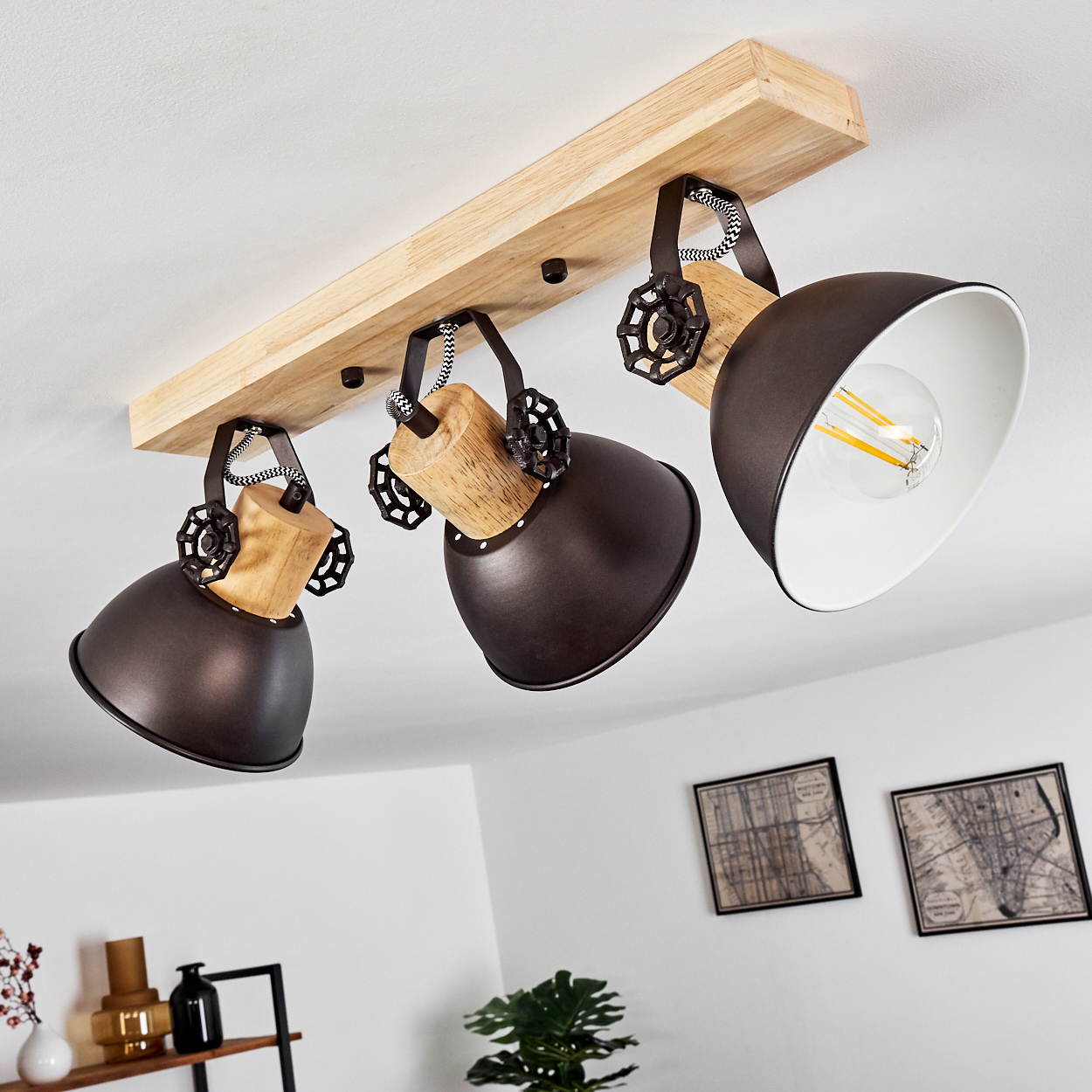 Holzbalkenlampe mit drei dunklen Schirmen und sichtbaren Glühbirnen.