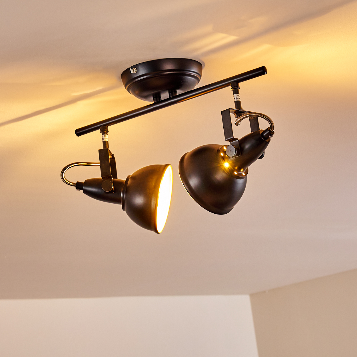 Schwarzer Deckenstrahler mit zwei verstellbaren Lampenköpfen.