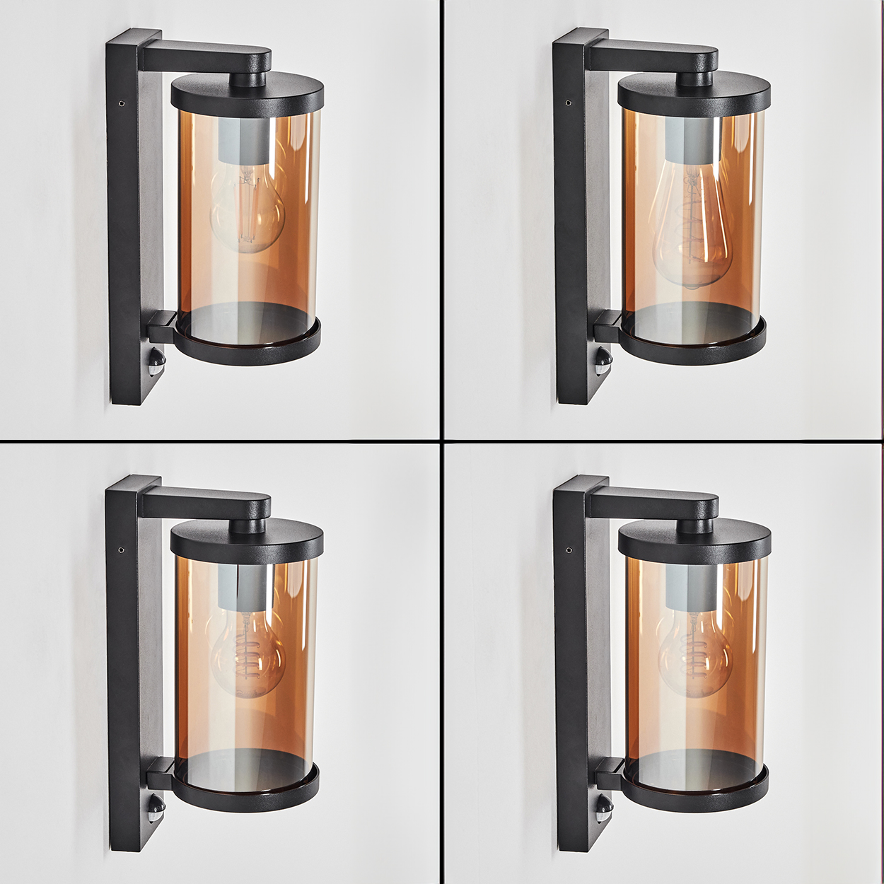 Schwarze Wandleuchte mit bernsteinfarbenem Glaszylinder und sichtbarer Glühbirne.