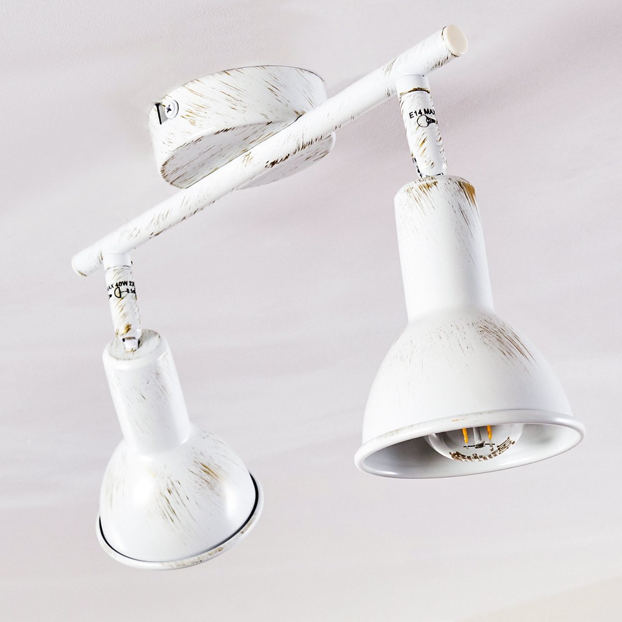 Eine weiße Deckenlampe mit zwei verstellbaren Spots, die an einem Stangenarm montiert sind.