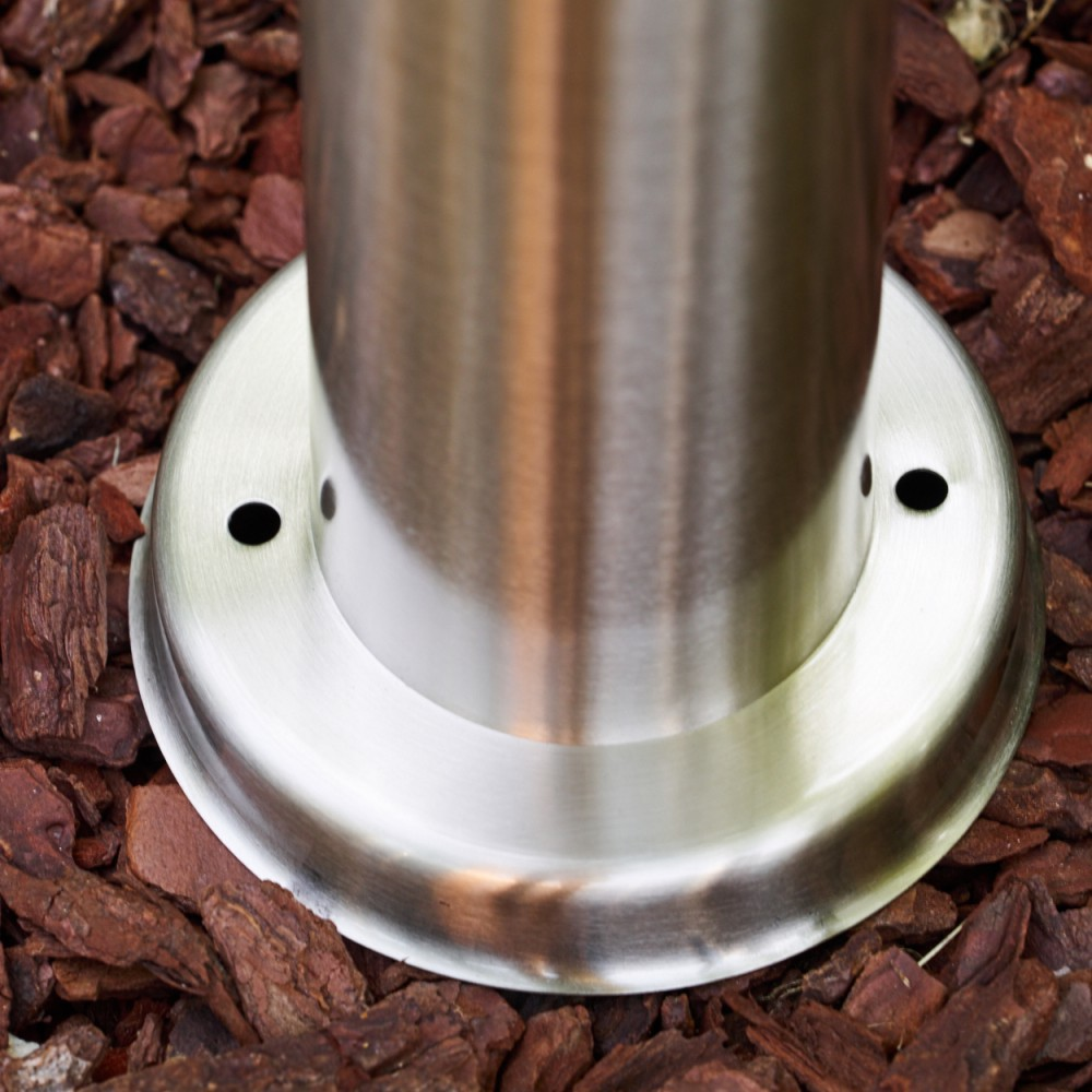 Metallpfostenbasis auf Rindenmulch mit zwei Schraubenlöchern.