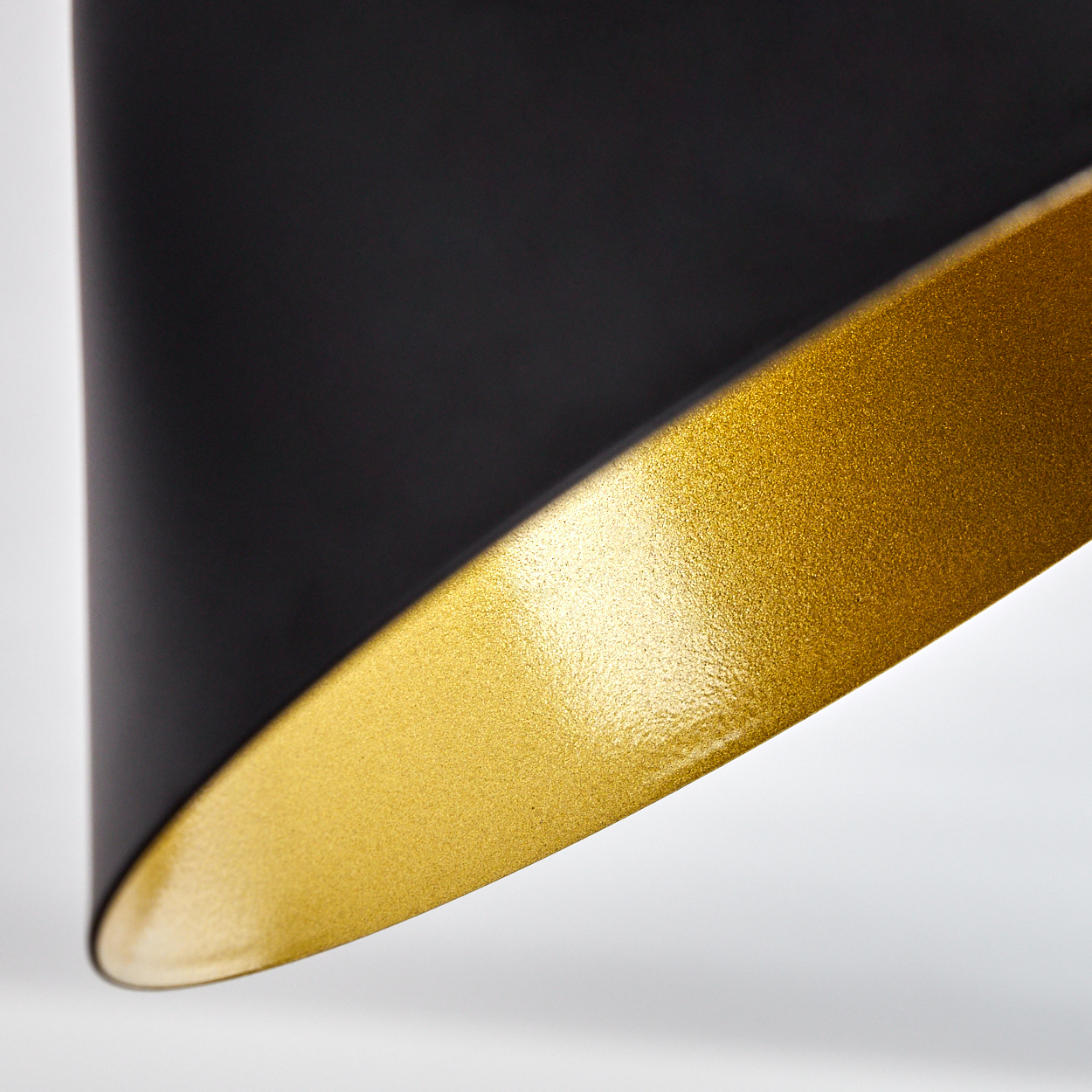 Nahaufnahme einer schwarzen und goldenen Lampe mit schimmernder Oberfläche.
