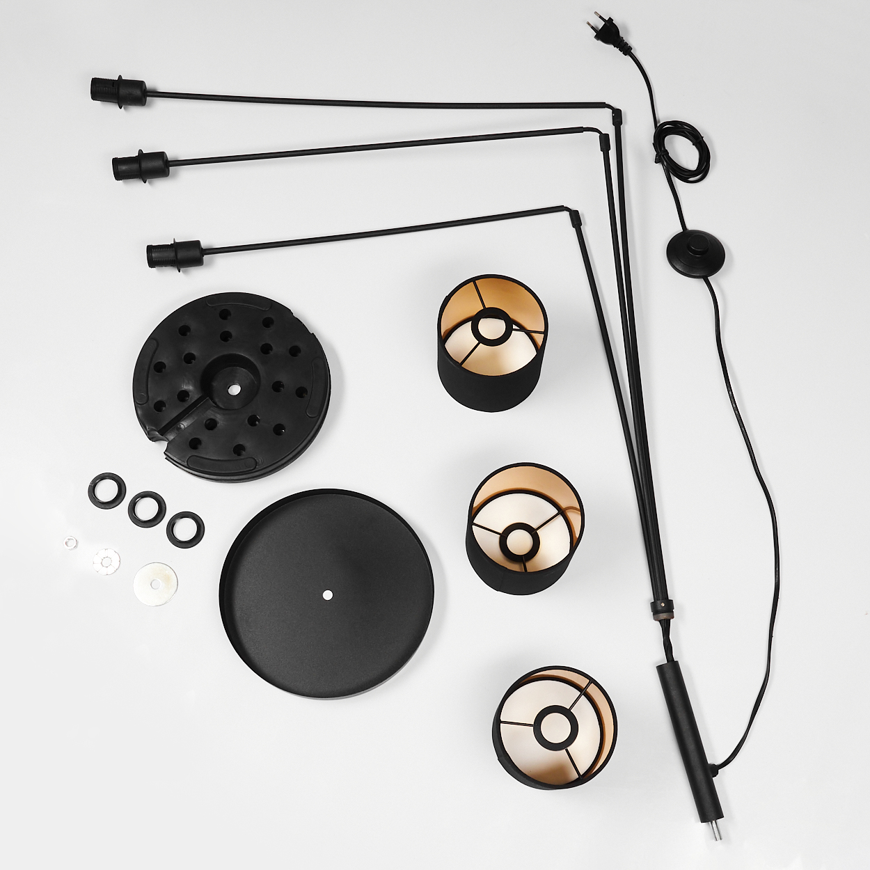 Teile einer schwarzen Stehleuchte: Sockel, Stangen, Lampenschirme, Kabel und Stecker.