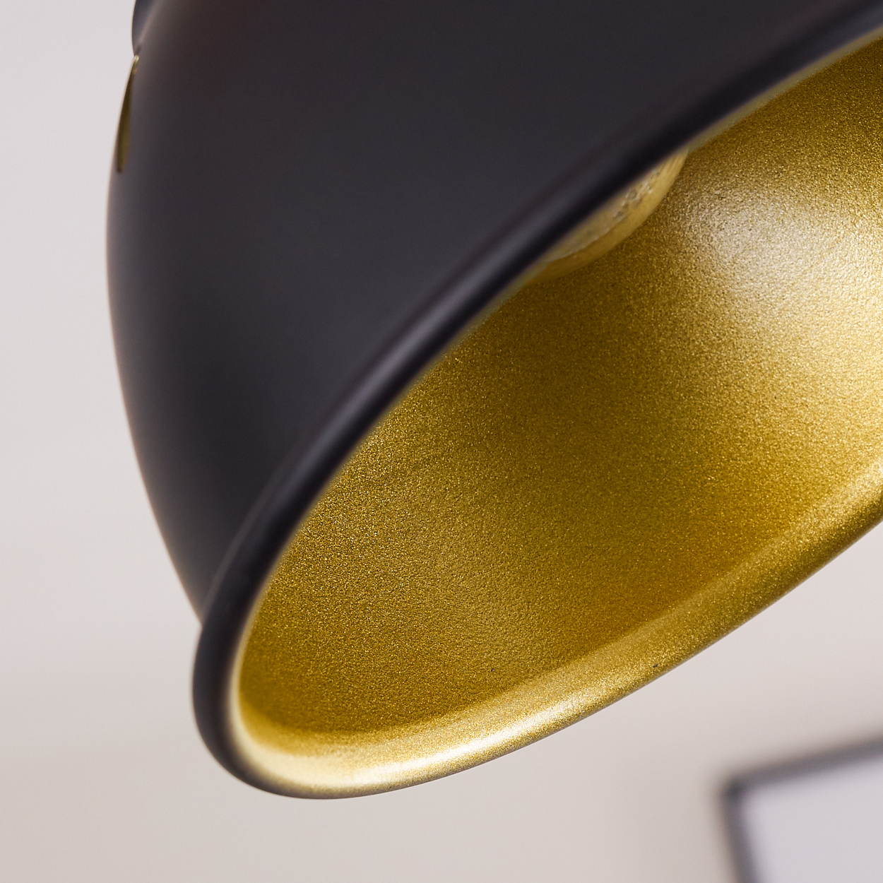 Nahaufnahme einer schwarzen Lampe mit goldener Innenseite.