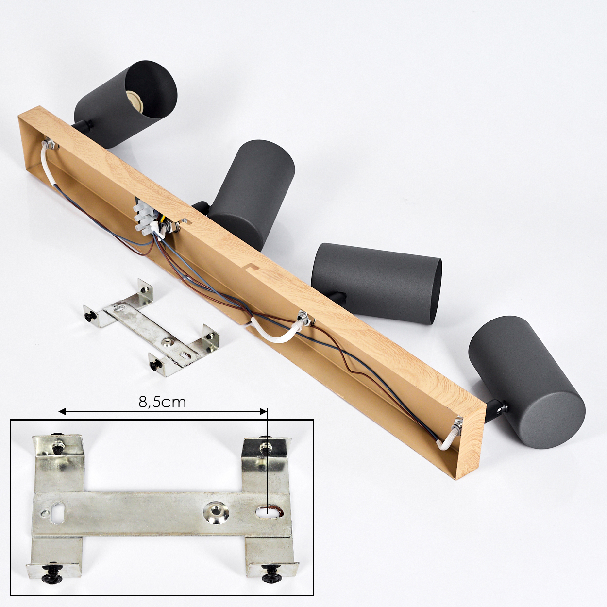 Ein dreiflammiger Lampenaufbau mit Holzsockel und schwarzen zylindrischen Lampenschirmen.
