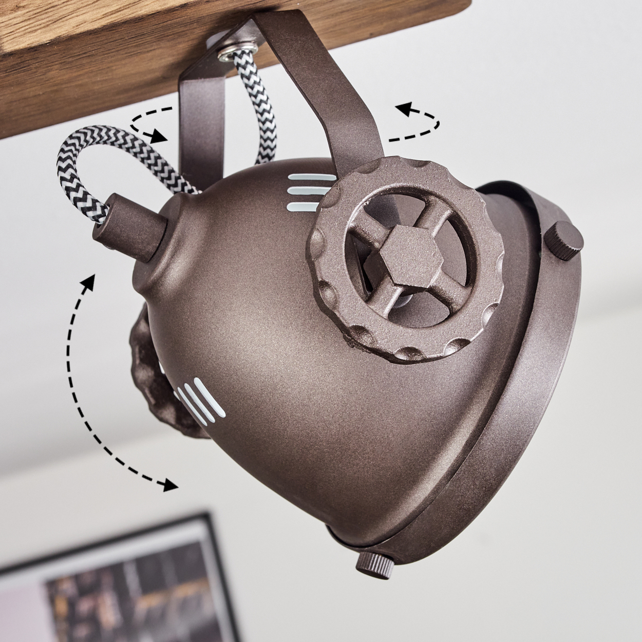 Eine braune Lampe mit Zahnraddetail, die an einem Holzstück hängt.