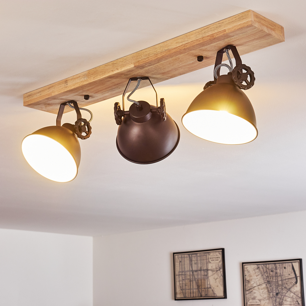 Eine Deckenleuchte mit Holzsockel und drei bronzenen Lampenschirmen.
