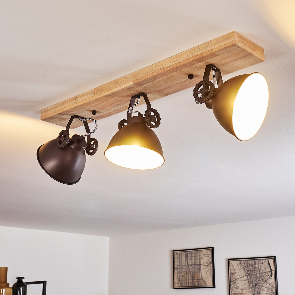 Deckenleuchte mit Holzsockel und drei verstellbaren Lampenschirmen in dunklem Metall.
