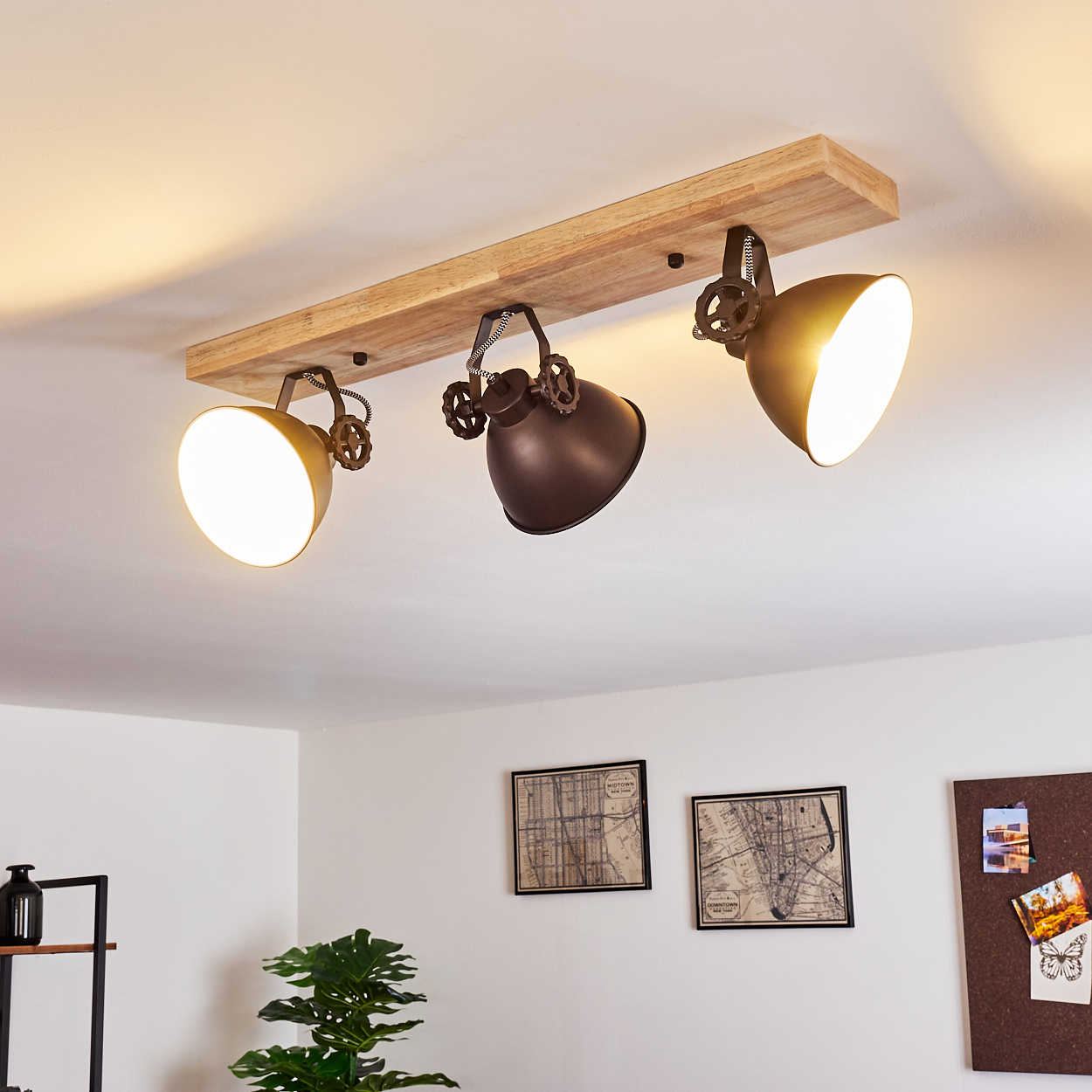 Holzdeckenleuchte mit drei Lampenschirmen, zwei goldfarben, einer braun.