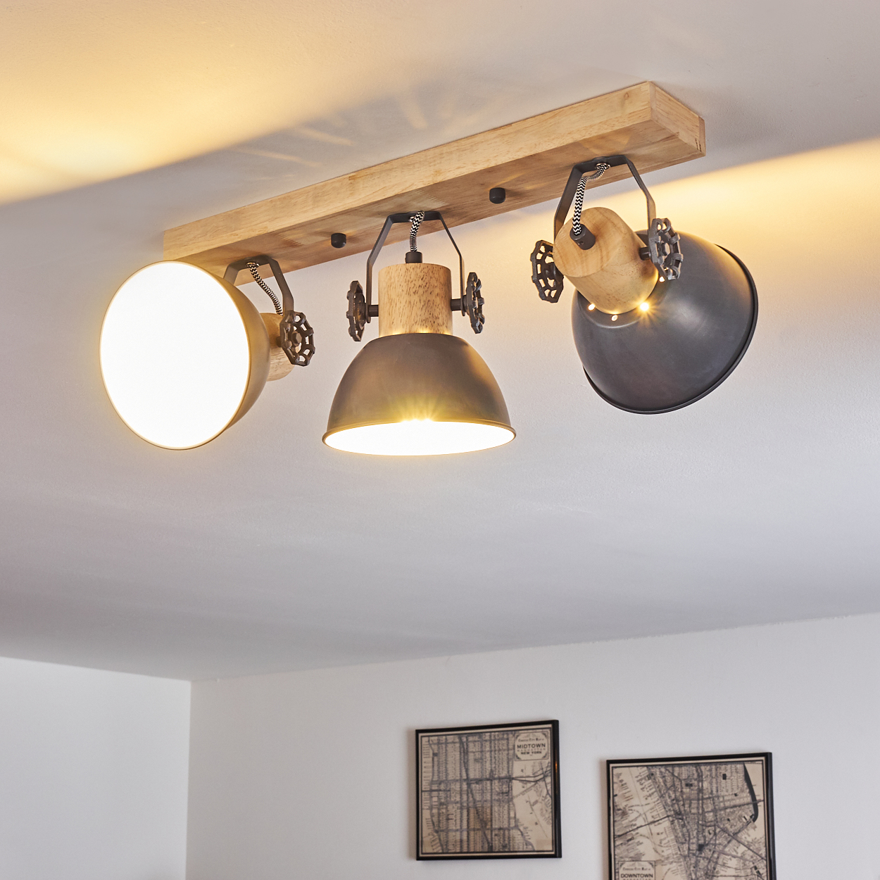 Deckenleuchte mit Holzsockel und drei verstellbaren Metallschirmen.