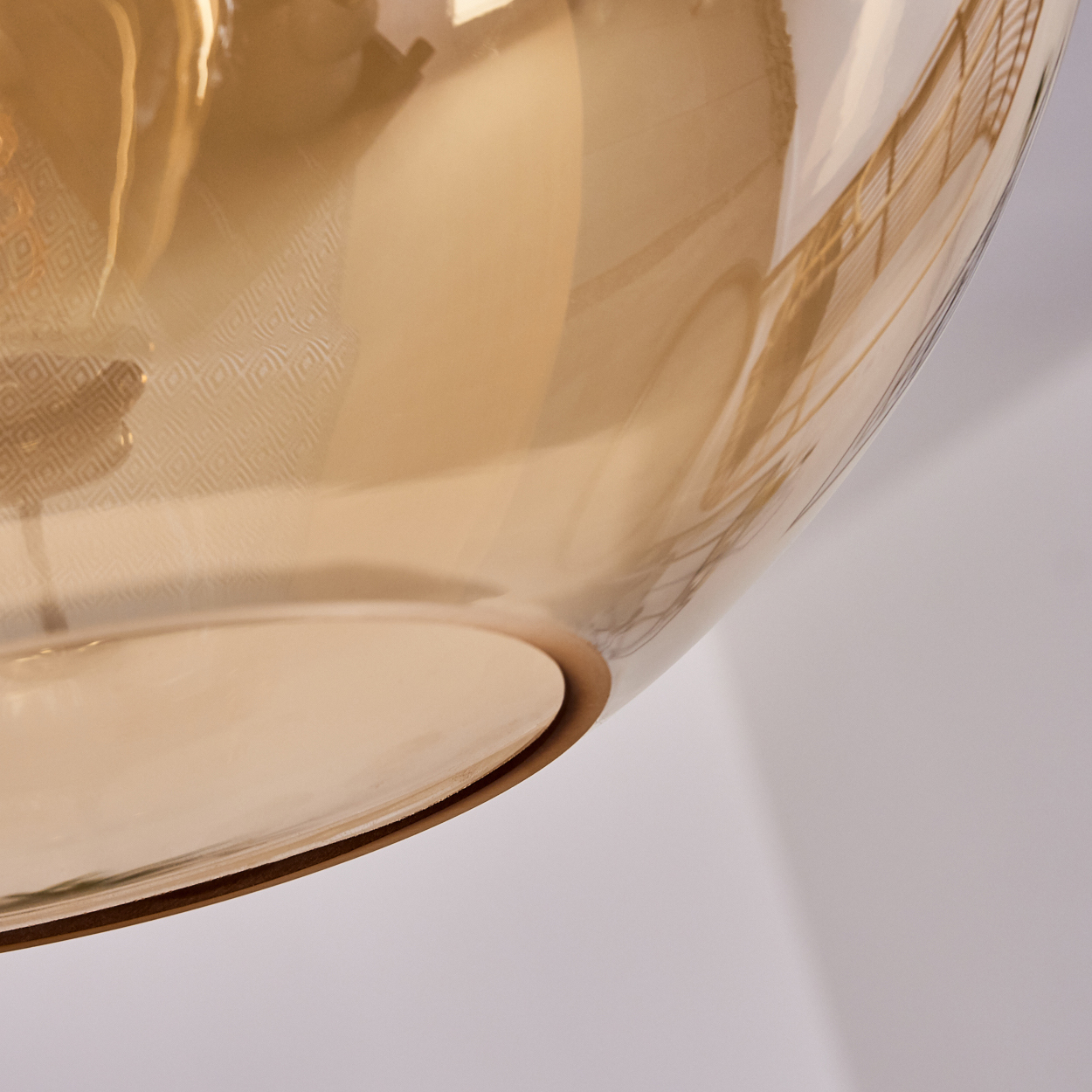 Bernsteinfarbene Glasvase mit Muster und Reflexionen auf weißem Hintergrund.