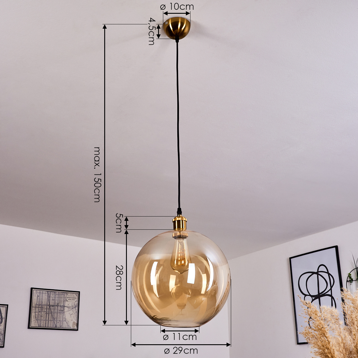 Eine bernsteinfarbene Glaskugel-Hängelampe mit Messingdetail hängt von der Decke.