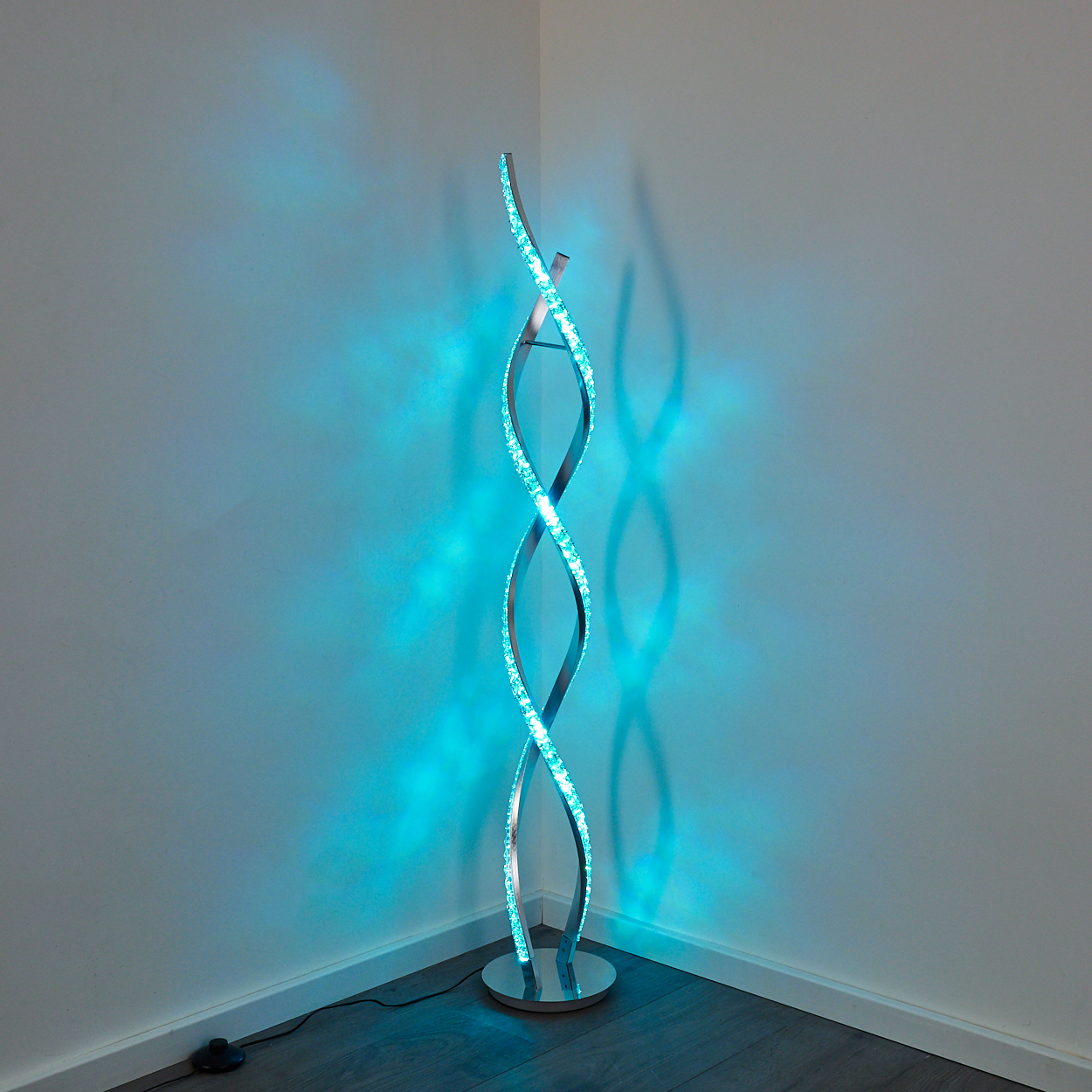 Moderne Stehlampe mit spiralförmigem Design und blauen LEDs, wirft Schatten.