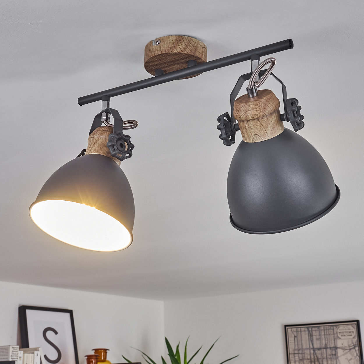 Zwei gerichtete Lampen mit Holzakzenten und schwarzen Metallschirmen an einer Stange.