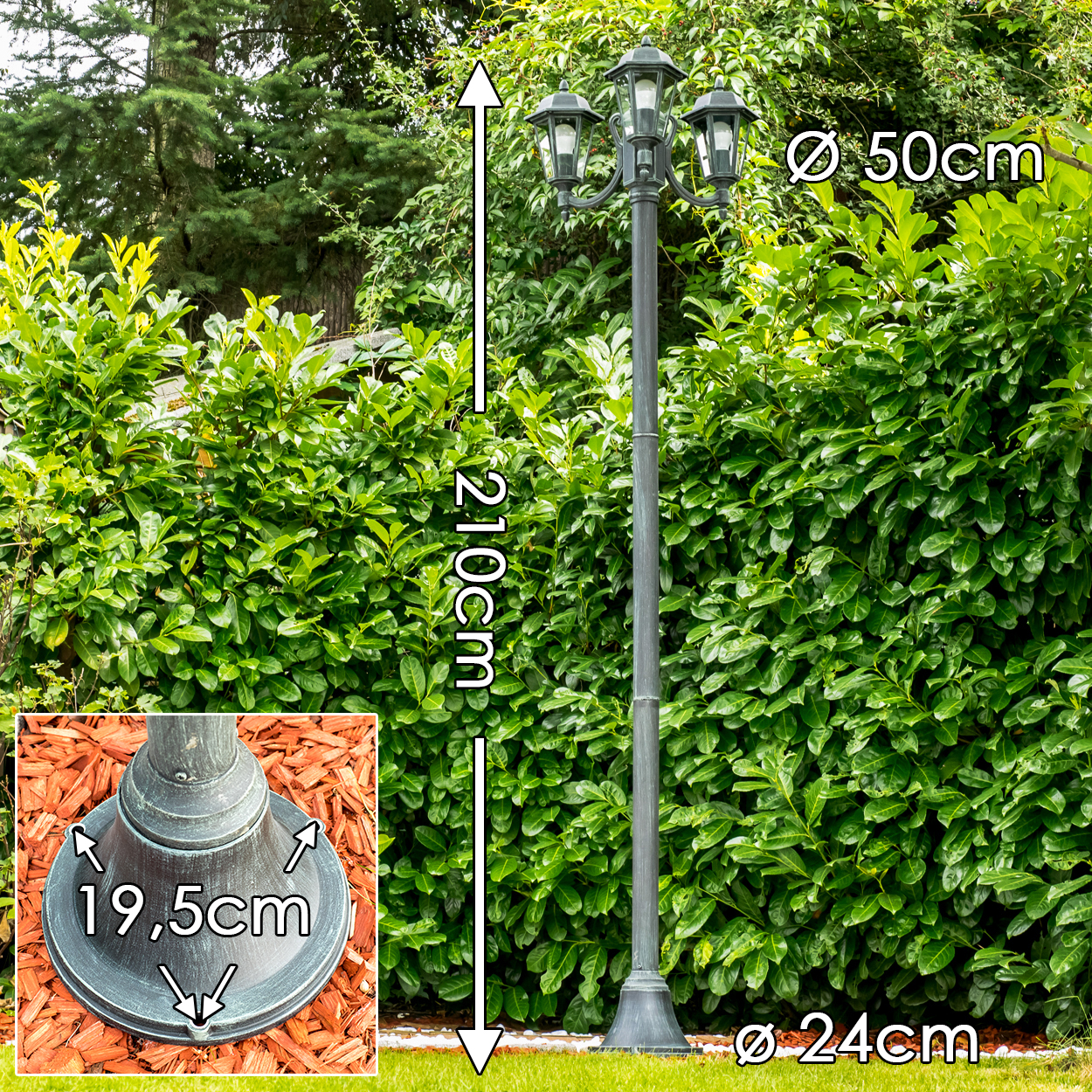 Ein dunkler Laternenpfahl mit drei Lampen steht im Garten.