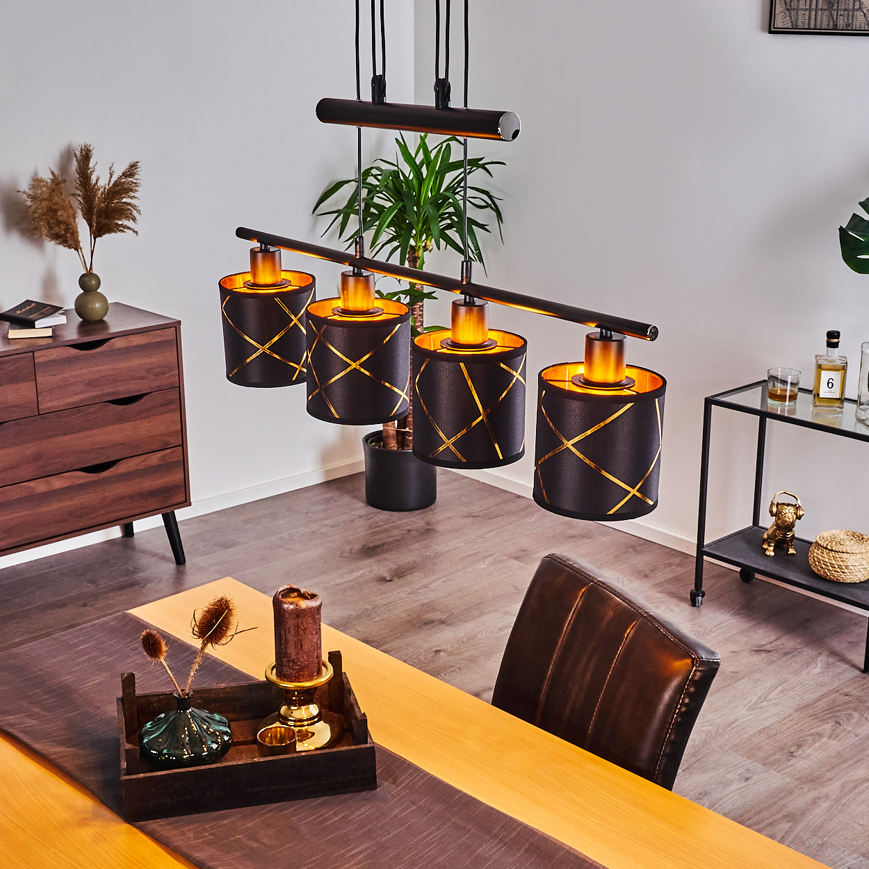 Ein Esszimmer mit dunklen Holzmöbeln, einer Hängeleuchte und braunen Ledersesseln.