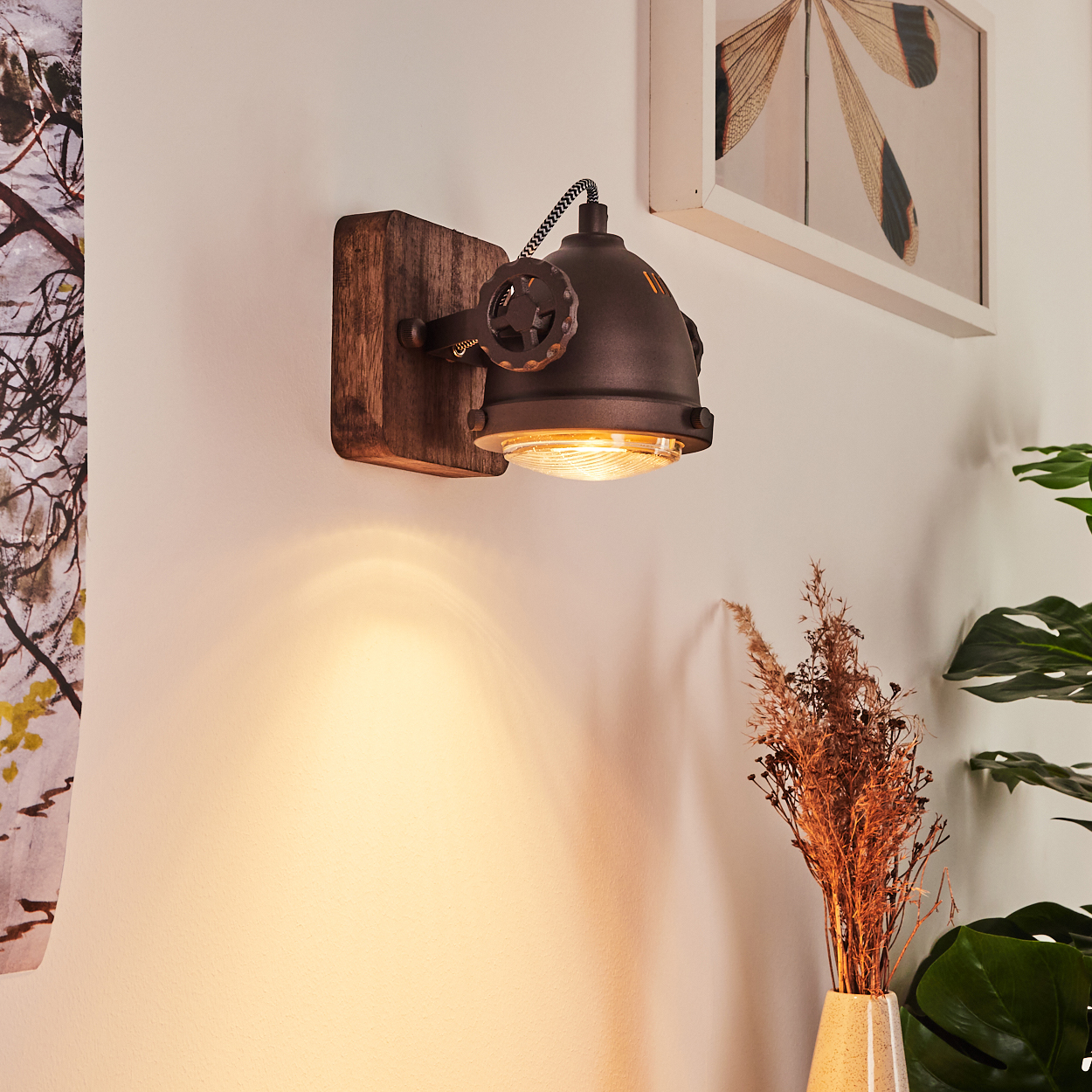 Eine Wandleuchte im Industriestil mit Holzsockel und dunklem Metallschirm.