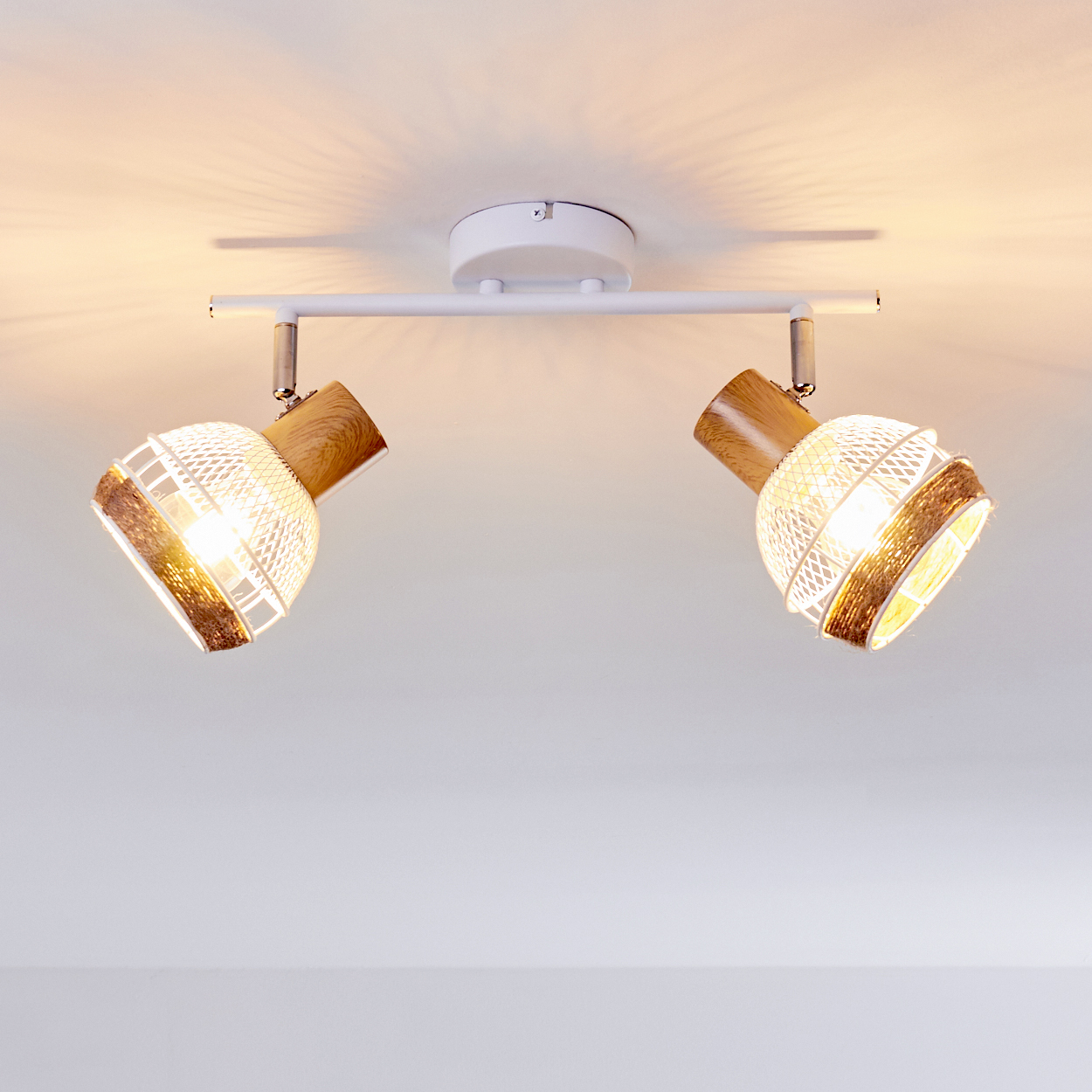 Zwei gerichtete Lampen mit Holzdetails an einer weißen Schiene an der Decke.