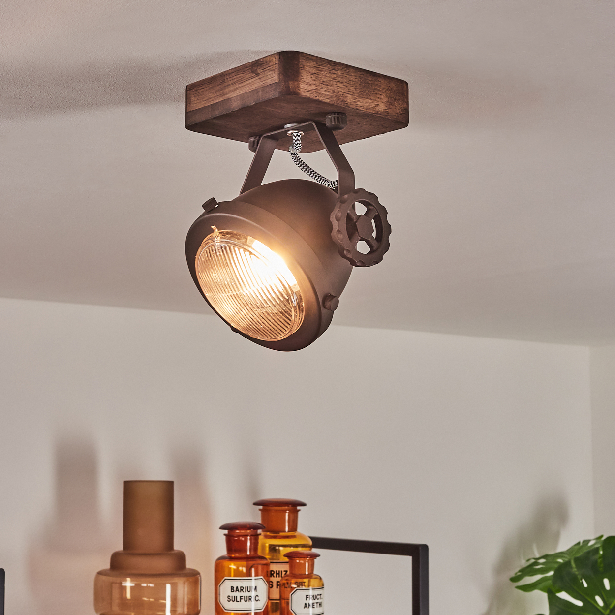 Industrielle Lampe mit Holzsockel und verstellbarem Metallschirm.