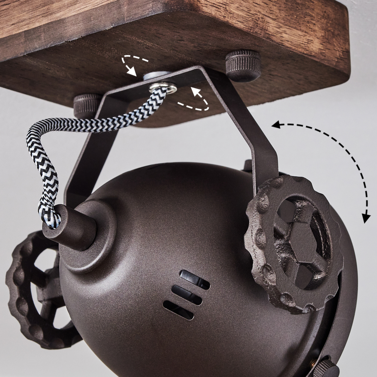 Dunkles Metalllicht mit Holzbasis und Zahnrad-Detail. Kabel mit Zickzackmuster.