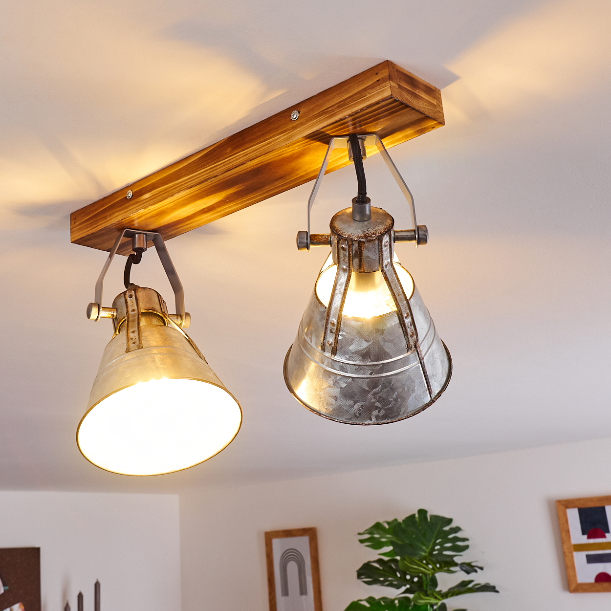Eine rustikale Deckenleuchte mit zwei Lampen im Industrie-Look auf einem Holzbalken.
