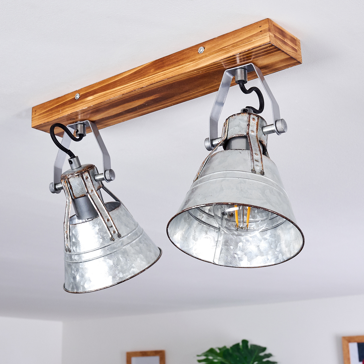 Zwei industrielle Metall-Spots mit Holzmontage an der Decke.