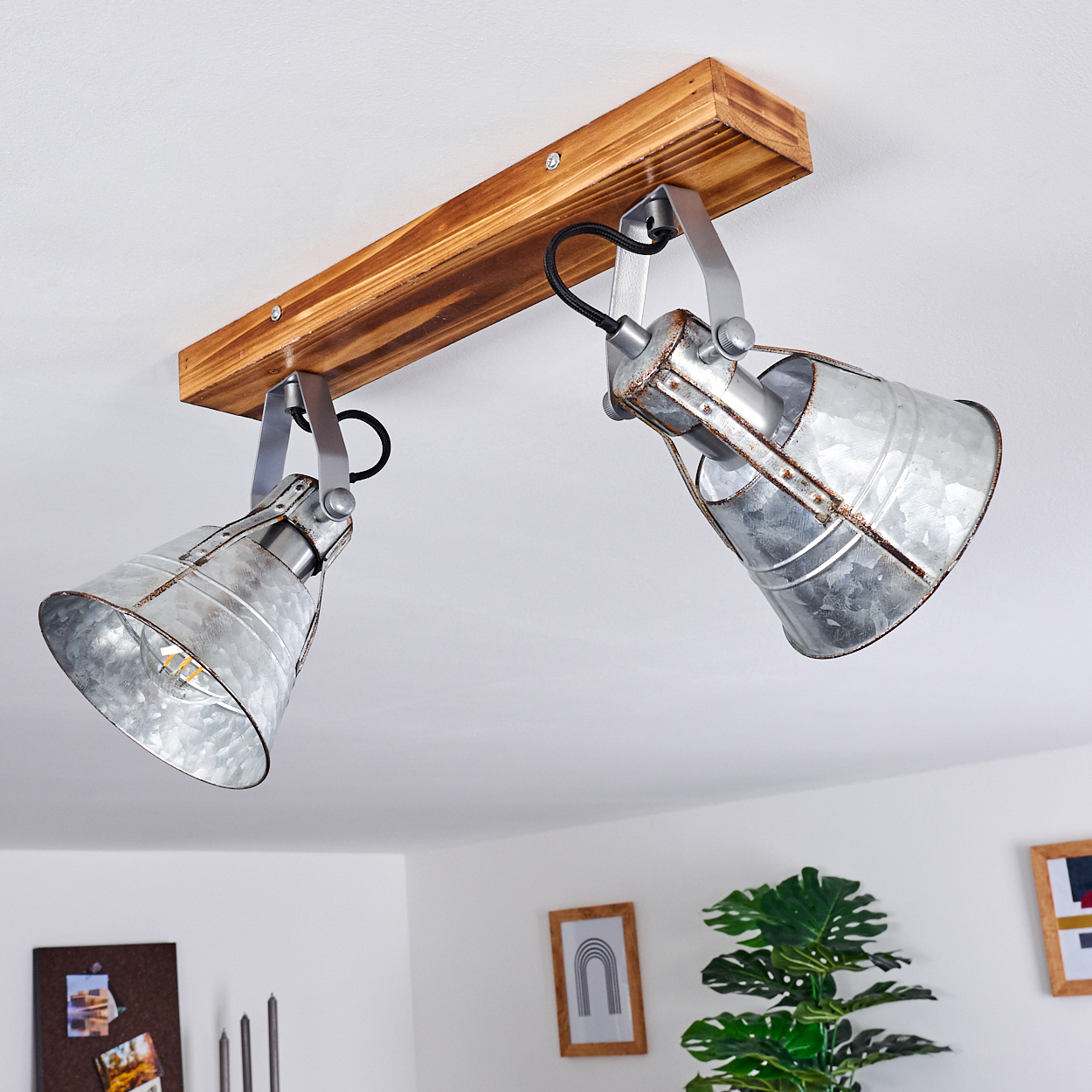 Zwei industrielle Metall-Spots an einem Holzbalken an der Decke.