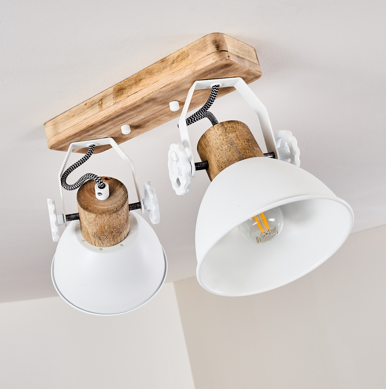 Zwei weiße Lampenschirme mit Holzakzenten an Holzbalken an der Decke.