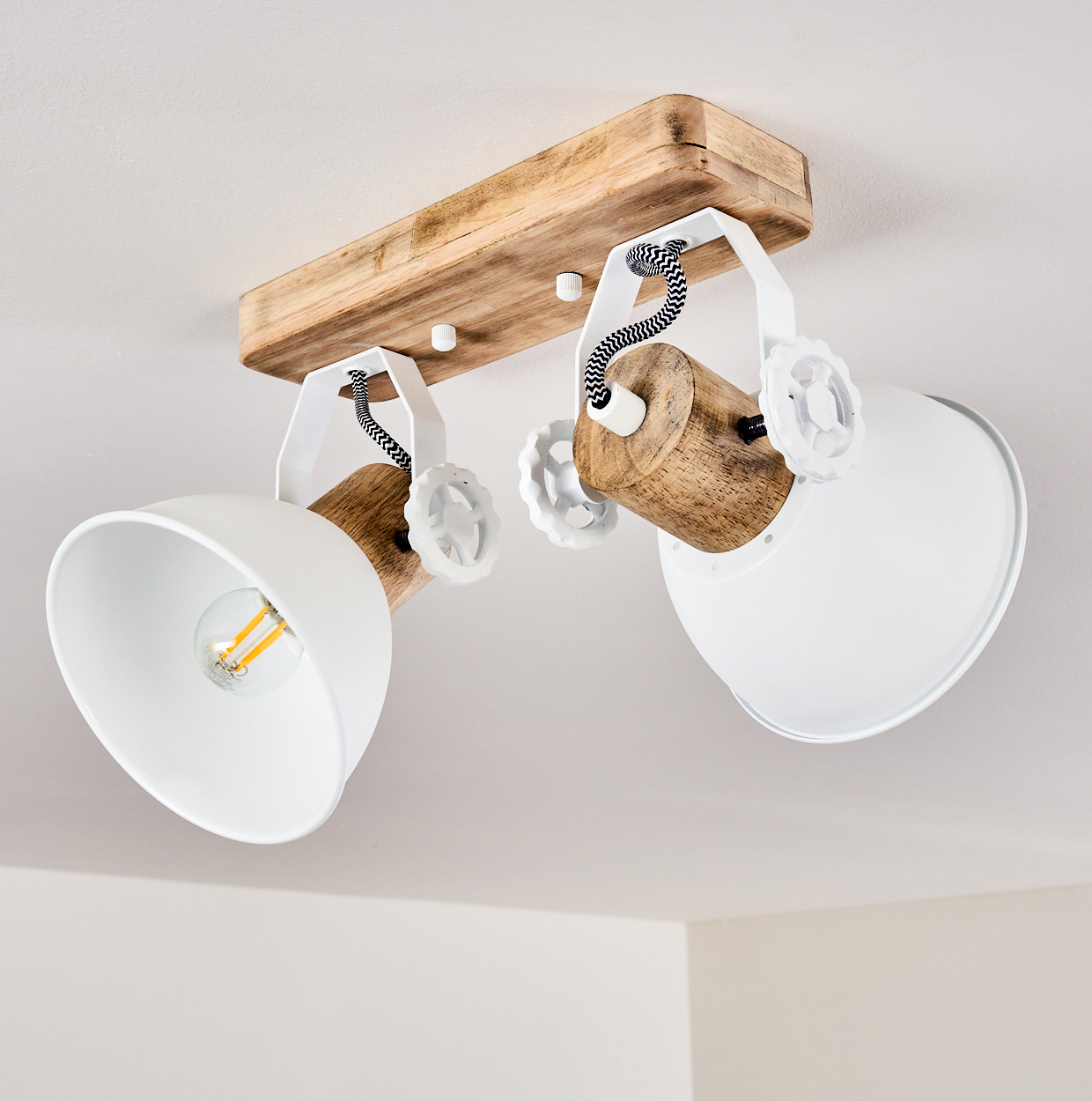 Deckenleuchte mit Holzsockel, zwei weißen Lampenschirmen und schwarzen Kabeln.