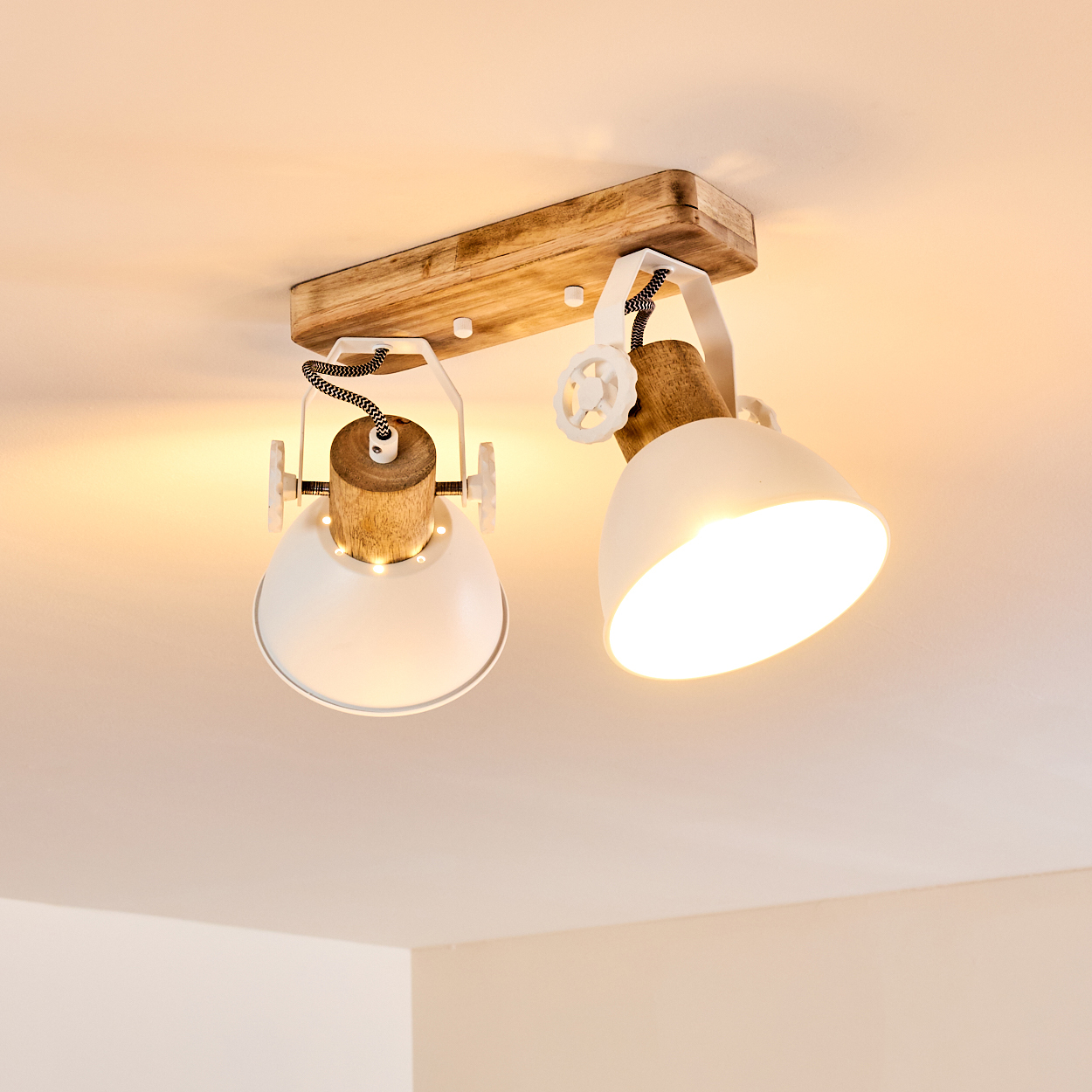 Holzdecke mit zwei weißen Lampenschirmen mit Holzdetails und schwarzen Schnüren.