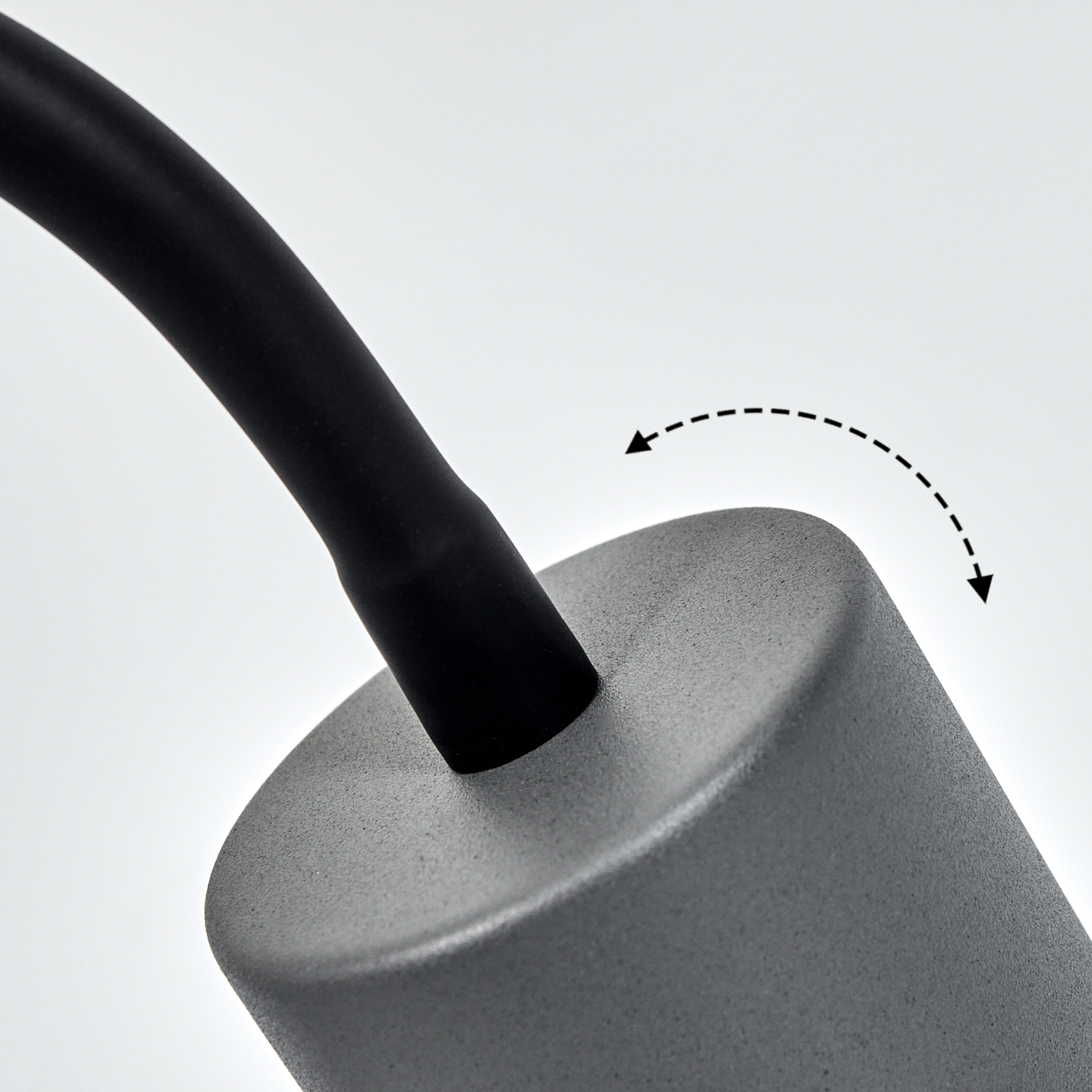 Ein schwarzes Kabel biegt sich über einen grauen Zylinder, mit Pfeilen, die eine Bewegung anzeigen.