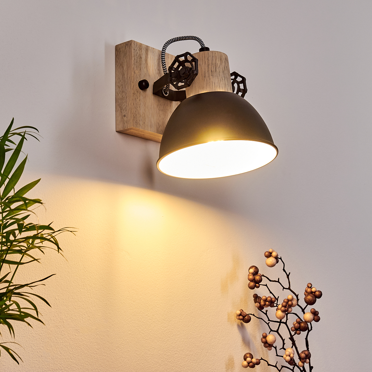 Eine Wandleuchte aus Holz mit einem dunklen Lampenschirm und Zierrädern.