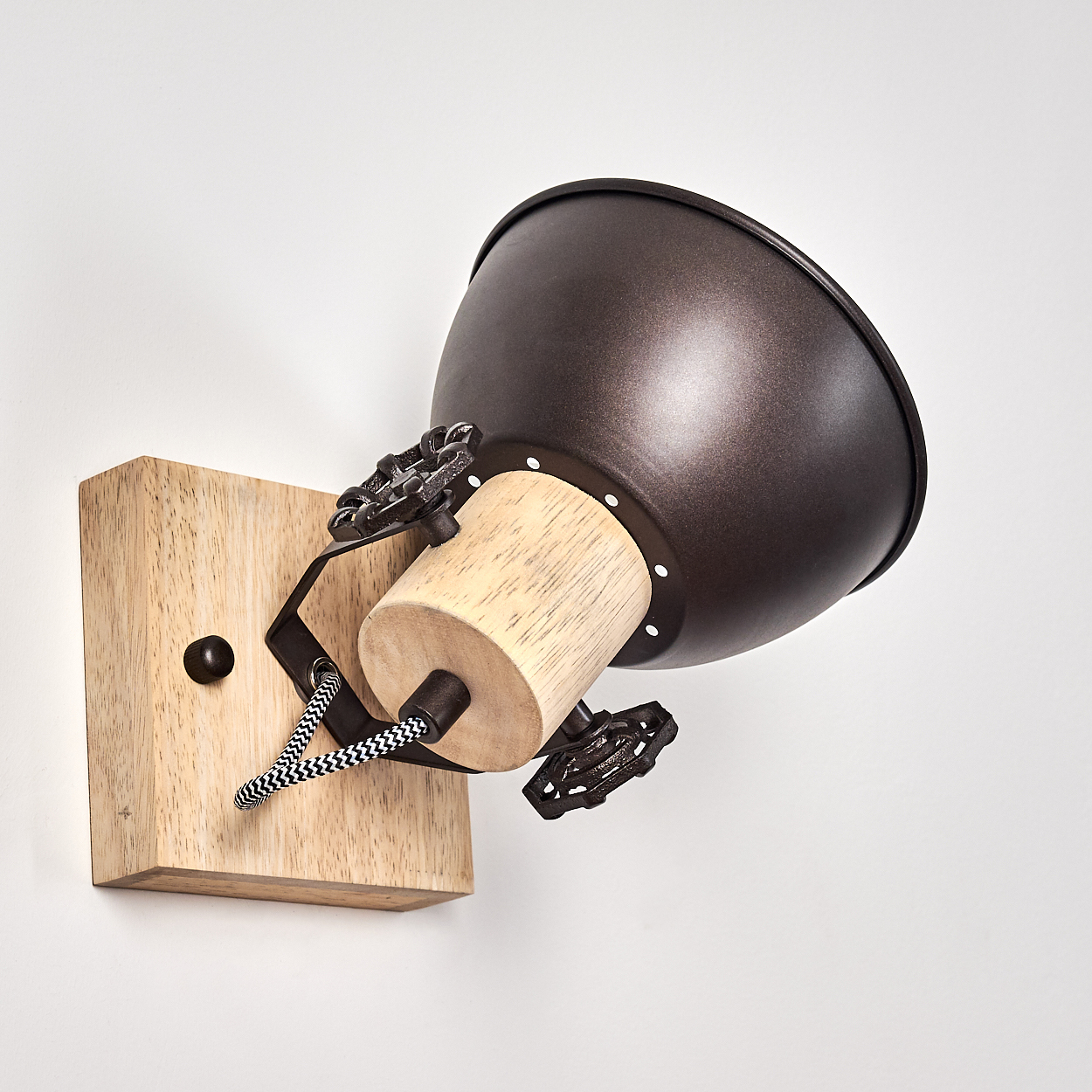 Ein industrieller Wandspot mit Holzsockel, Metallschirm und dekorativen Griffen.
