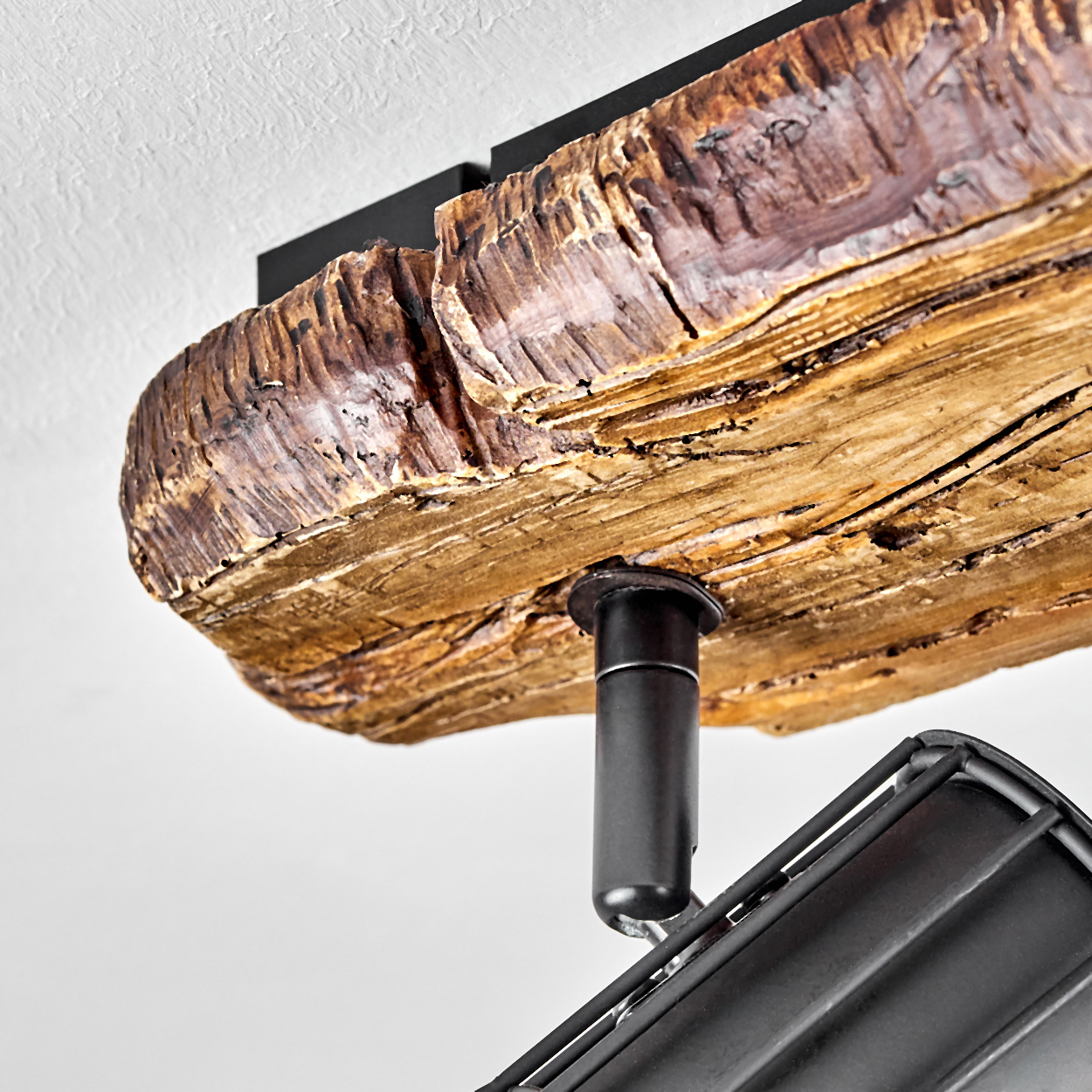 Eine rustikale Holzleiste mit schwarzer Metallhalterung und Lampe.