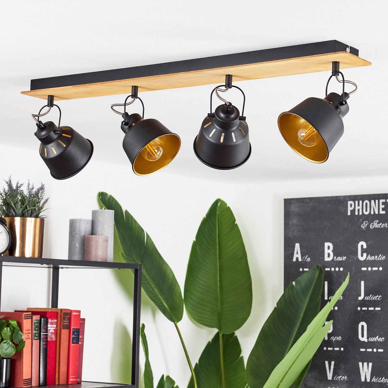 Schwarze Pendelleuchte mit Holzsockel, vier Lampenschirmen und Golddetails.