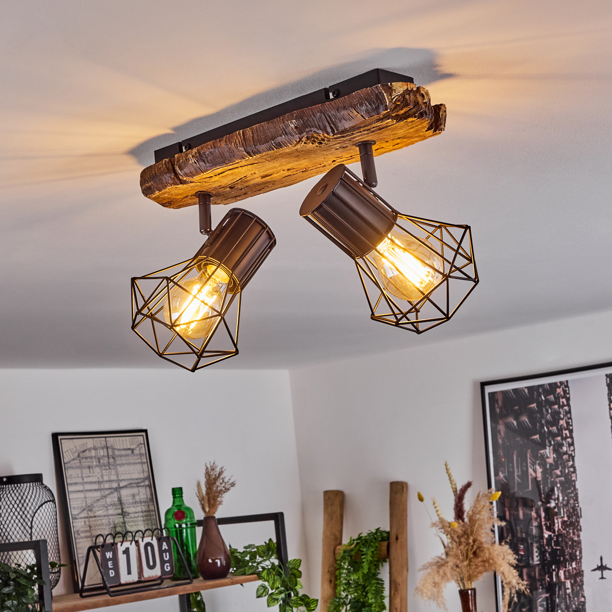 Deckenleuchte mit Holzsockel und zwei Käfiglampen aus dunklem Metall.