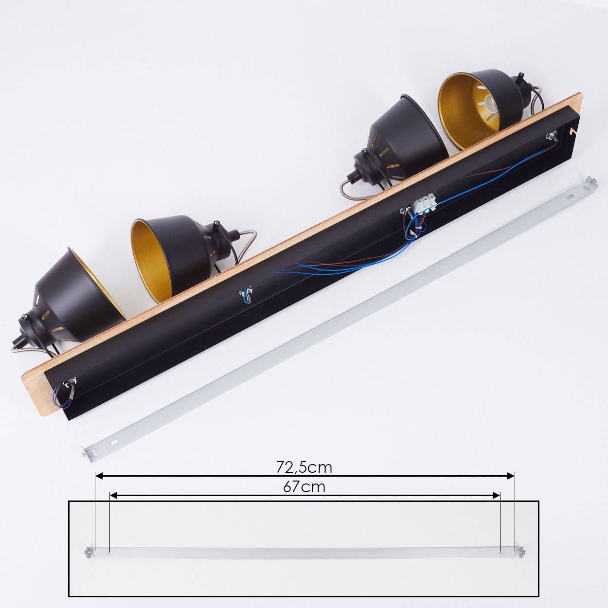 Ein schwarzer Deckenleuchter mit vier Lampenschirmen mit goldener Innenseite auf Holzlaminat.