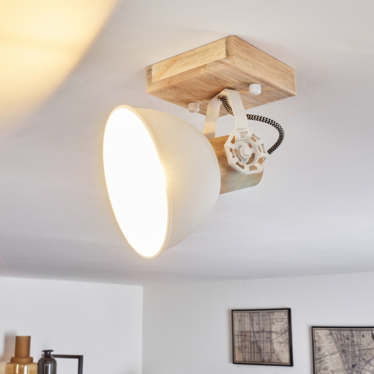 Eine weiße Deckenleuchte mit Holzbefestigung und verstellbarem Lampenschirm.