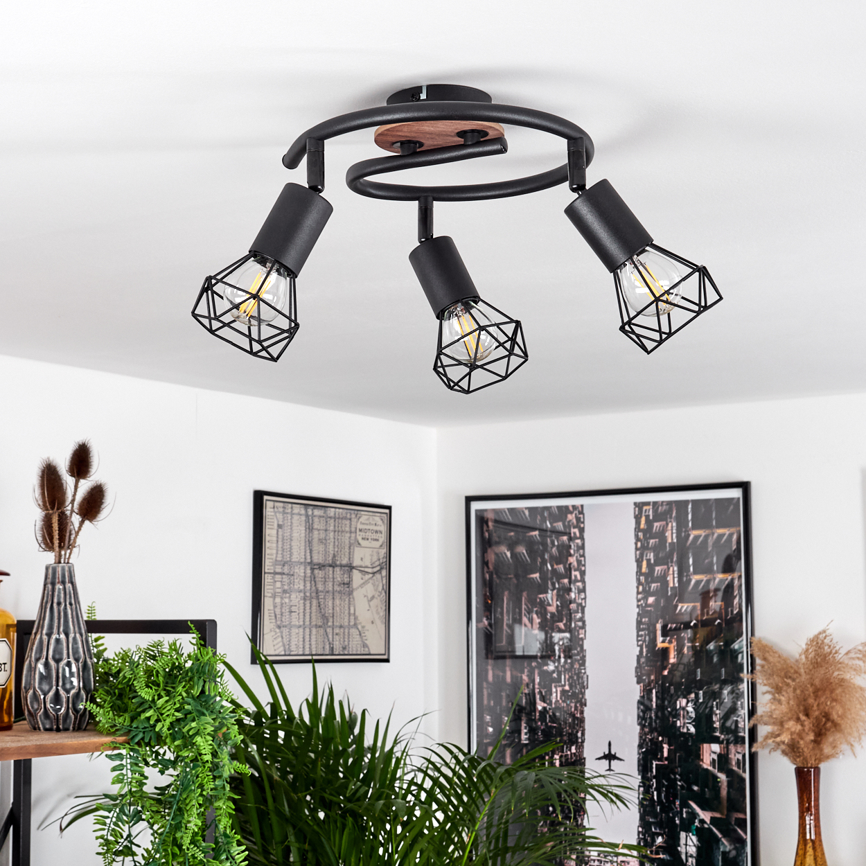 Schwarzer Deckenstrahler mit drei Lampen und Käfigschirmen, Holzdetail.