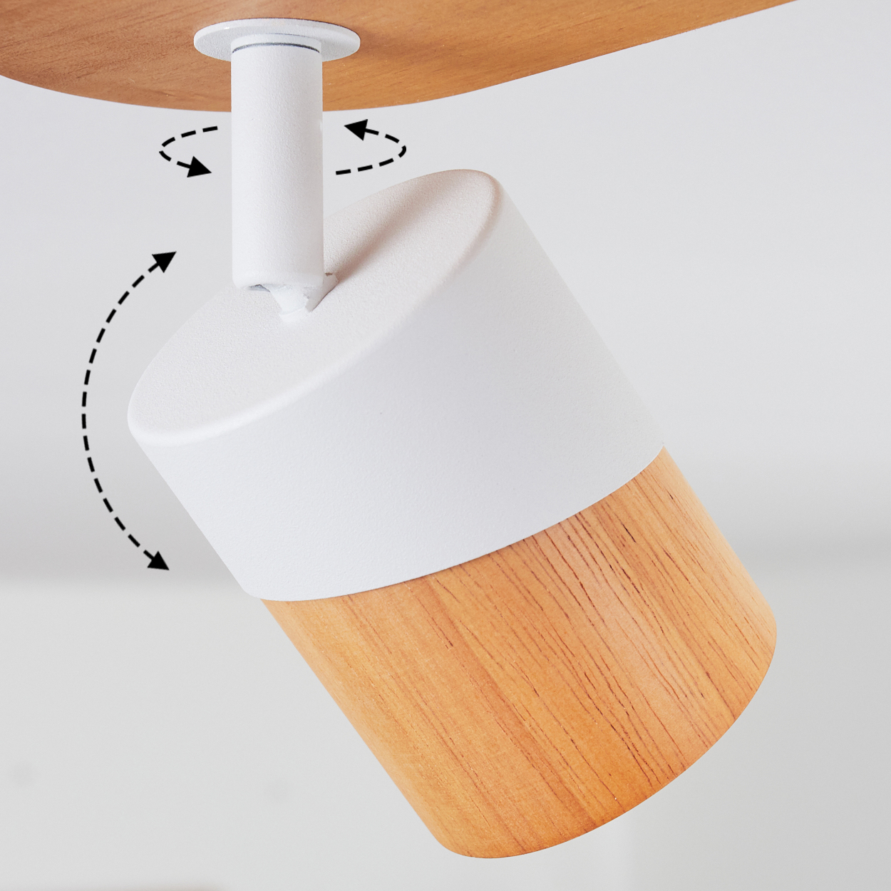 Ein schwenkbarer Deckenstrahler mit weißem Gehäuse und Holzdetails.