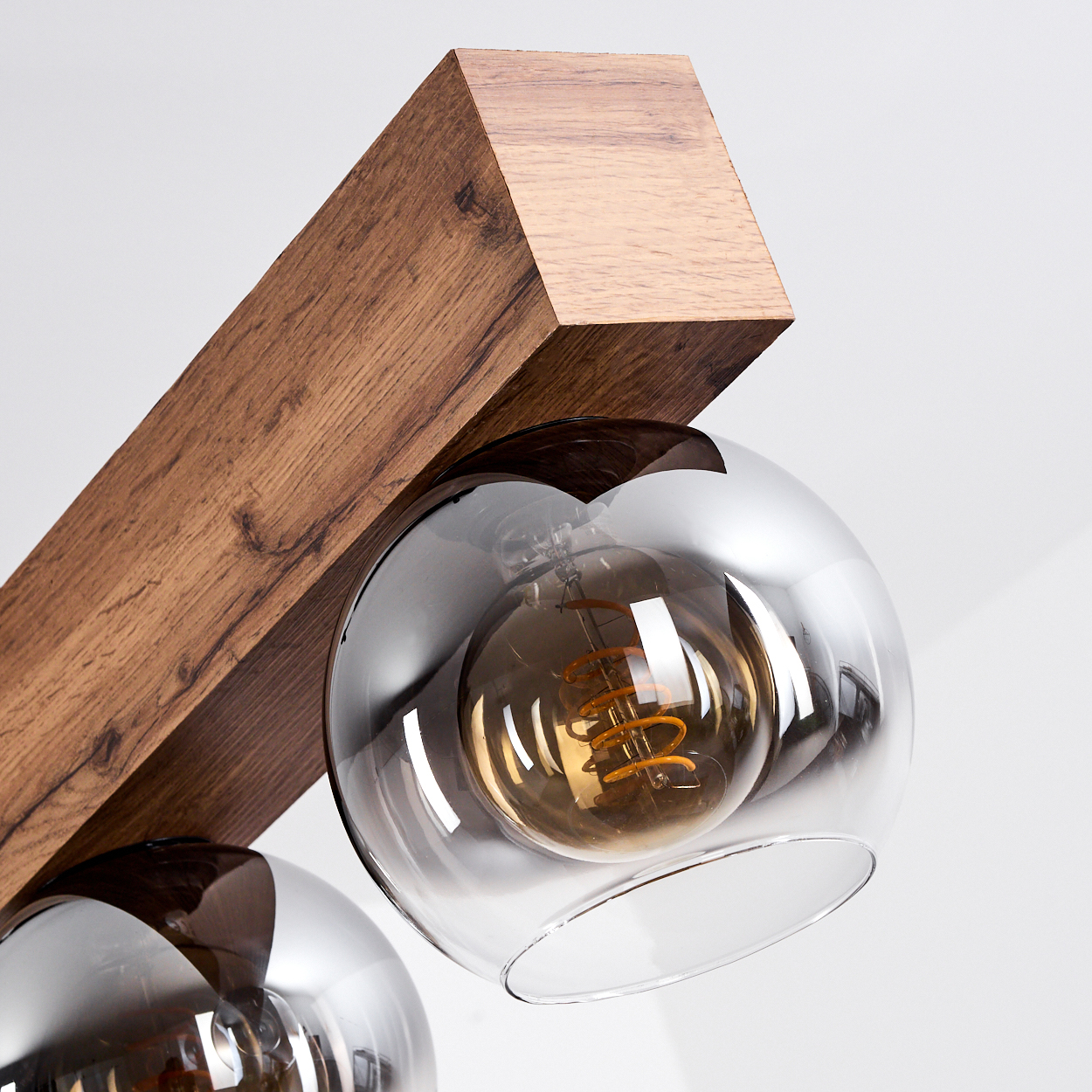 Holzbalken mit zwei Glaskugelleuchten und Glühbirnen.