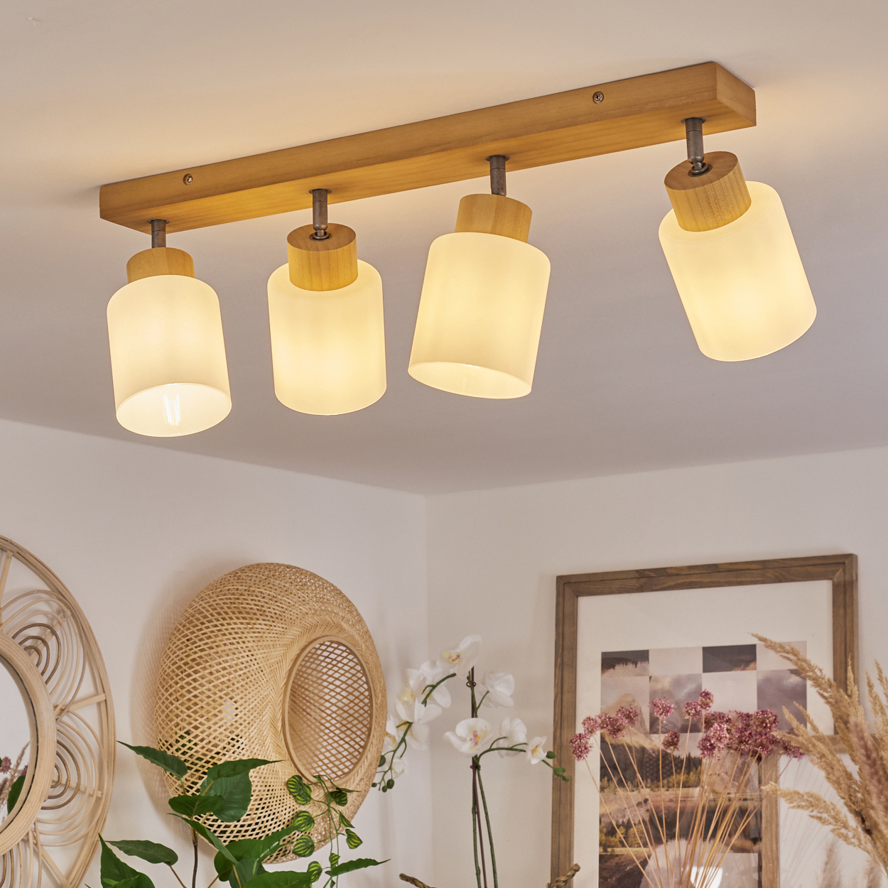 Holzdeckenleuchte mit vier Milchglaszylindern, die an einem Holzbalken befestigt sind.