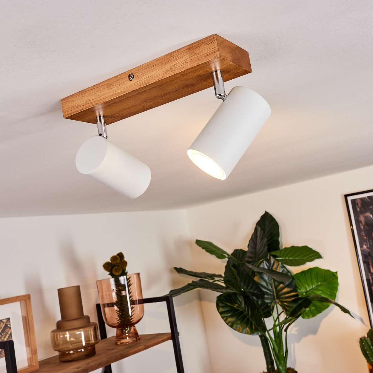 Deckenleuchte mit Holzbasis und zwei weißen Spots, daneben Pflanzen.