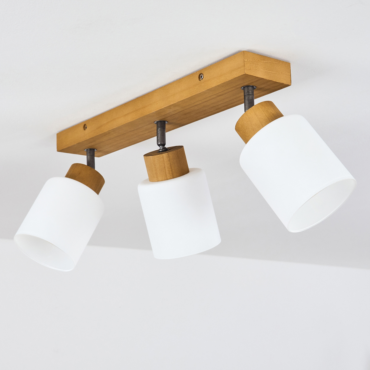 Deckenleuchte mit drei weißen Lampenschirmen und Holzdetails.