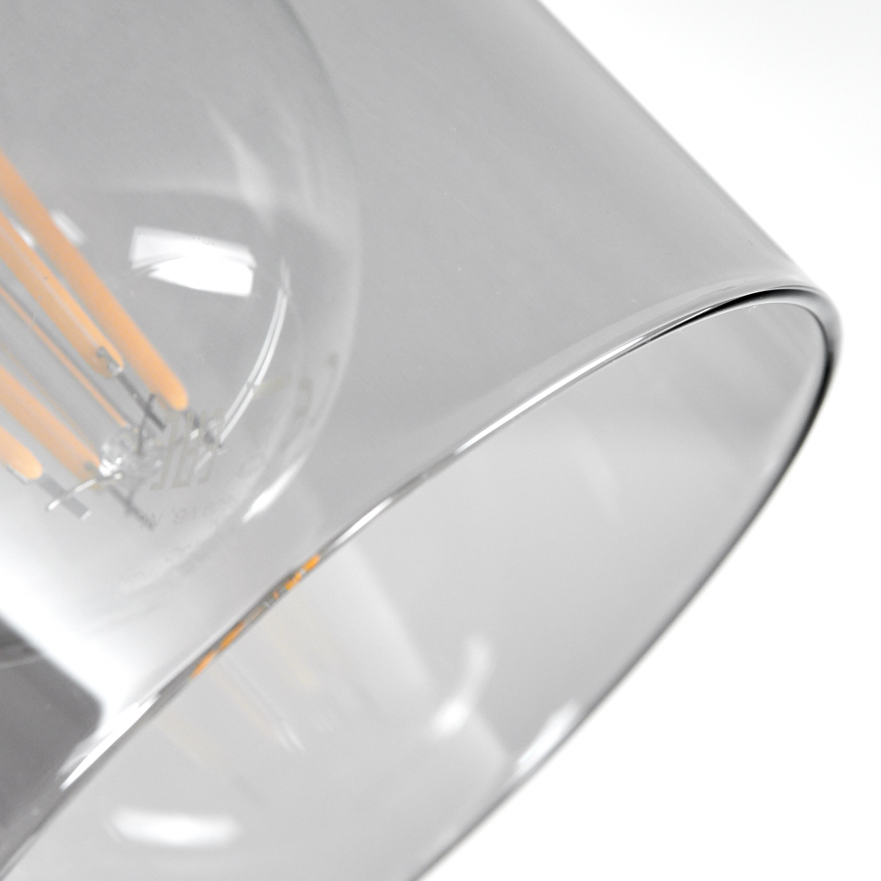 Nahaufnahme einer Glühbirne mit sichtbaren Filamenten in einem Glaszylinder.