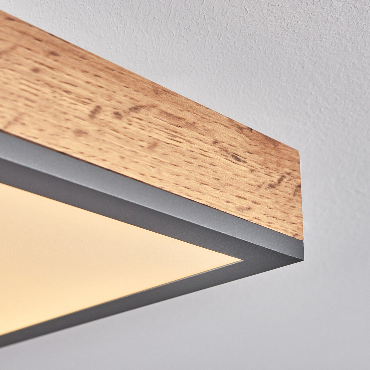 Holzdekor-Deckenleuchte mit dunklem Metallrahmen und beleuchteter Fläche.