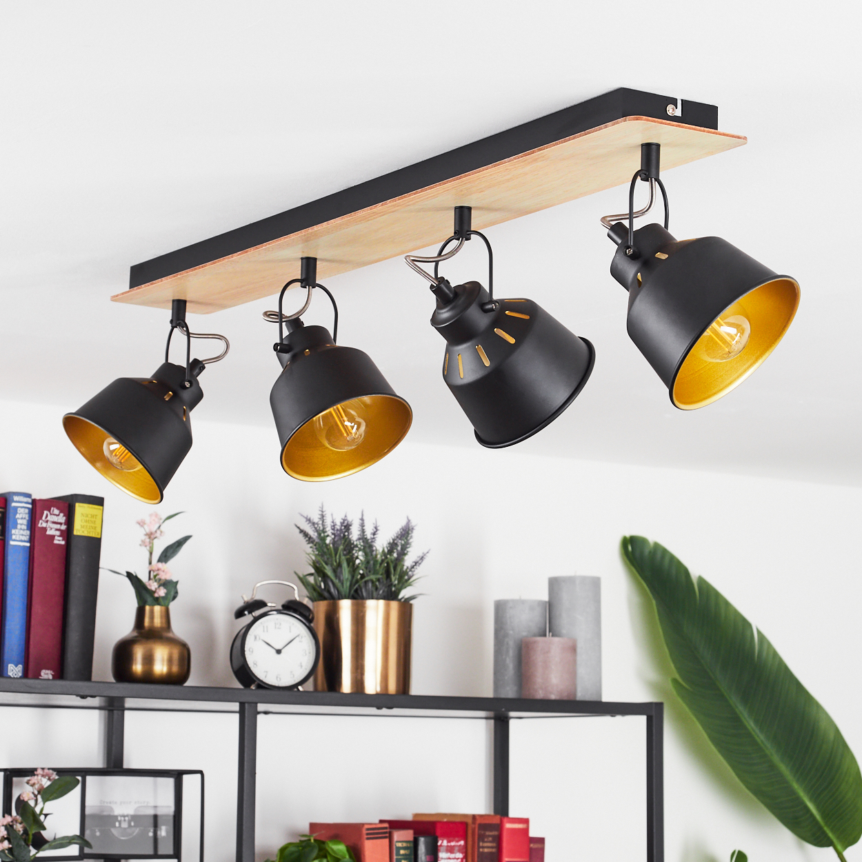 Schwarze Deckenleuchte mit vier Lichtern auf Holzbasis mit goldenen Akzenten.