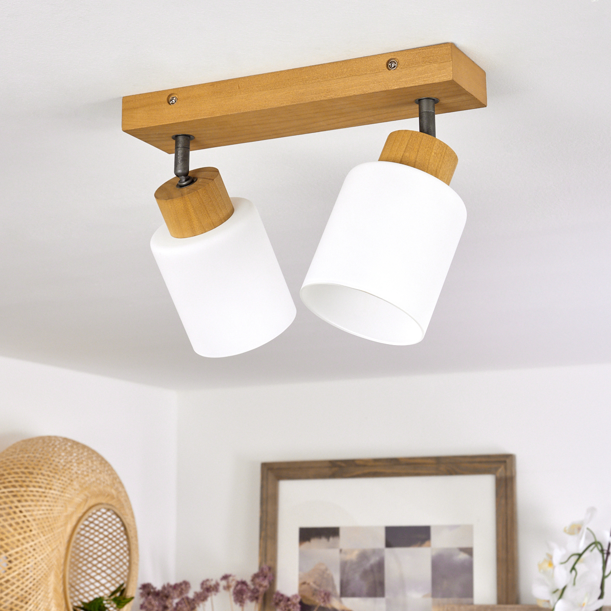Zwei weiße Lampenschirme mit Holzdetails an einer Holzstange an der Decke.