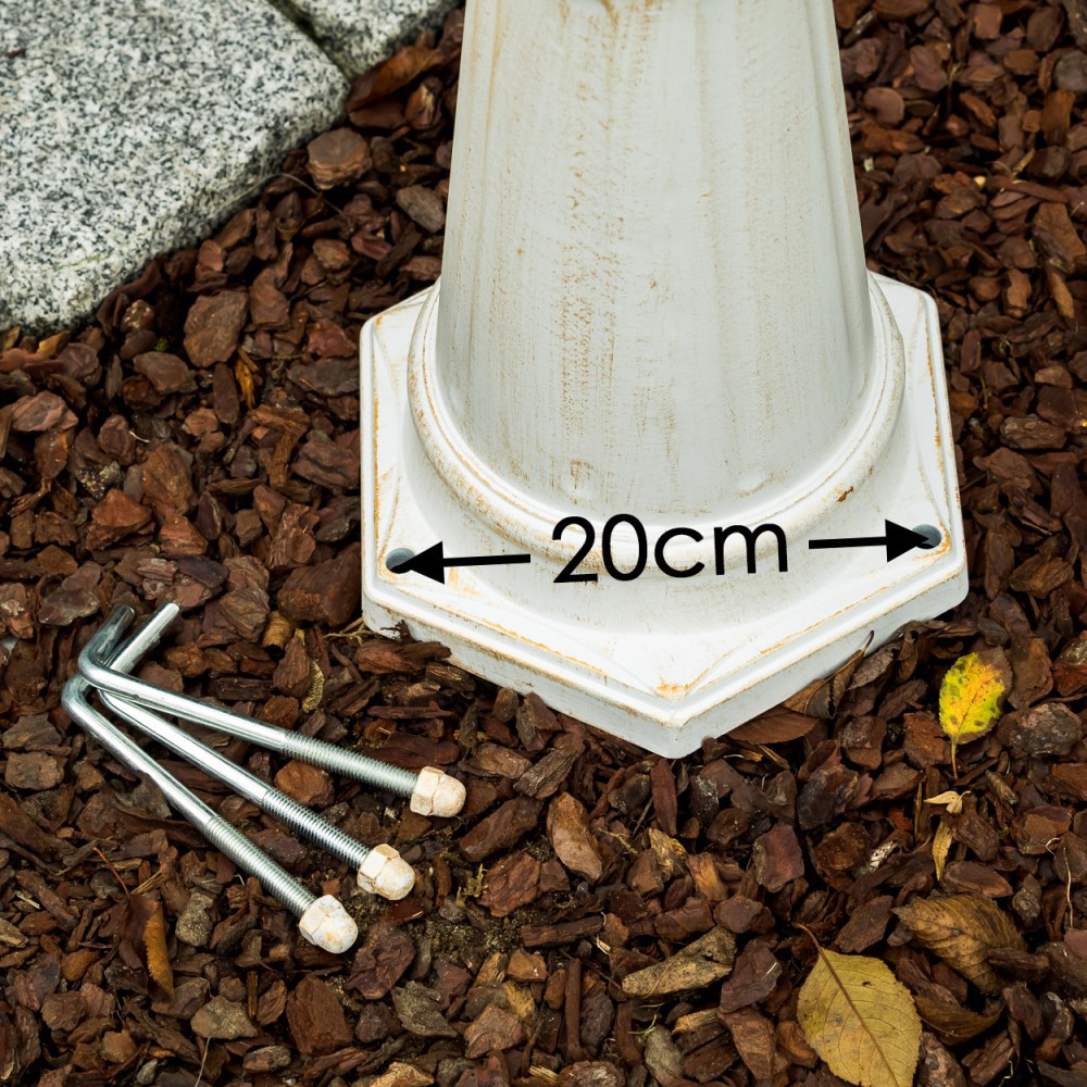 Ein weißer Sockel mit 20cm Markierung, daneben drei Erdspieße im Rindenmulch.